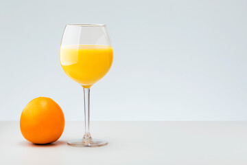 Fresh orange and glass with juice on grey background with copy space. Healthy vitamin drink.