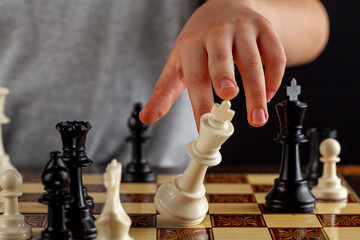 Close up image of the end of a chess game where the losing player resigns by tipping over his king. Image shows as the king falls down. Versatile image for defeat, failure and resignation concepts.
