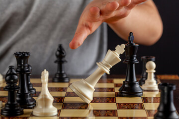 Close up image of the end of a chess game where the losing player resigns by tipping over his king....