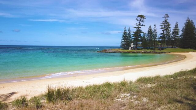 Right to left panning motion view of Emily Bay with sandy beach and beautiful colored waters and reef, Kingston, Norfolk Island, Australia