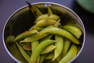 Roasted Edamame - Japanese traditional soybeans appetizer in a metal bowl on black backgrounds