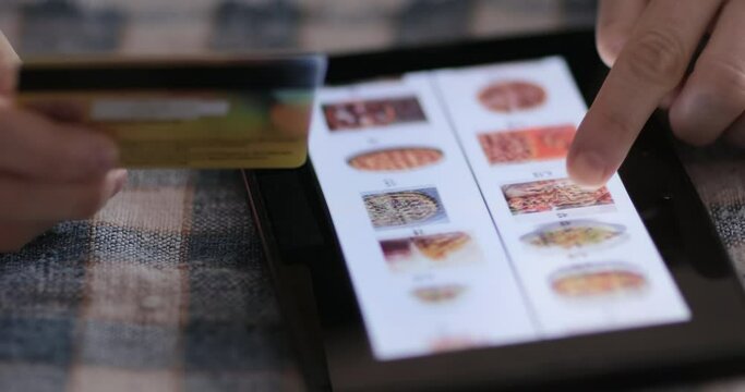 Browsing fast food menu on tablet and making online order. Online shopping concept.
