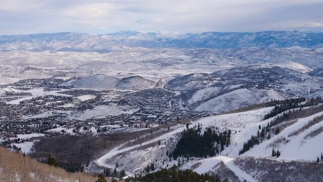 The high altitude view of Park City as seen from Red Pine Gondola up on the mountain. Filmed in 4k60 and slowed down for a slow motion look,  you can see the snowy ski runs and the downtown area.