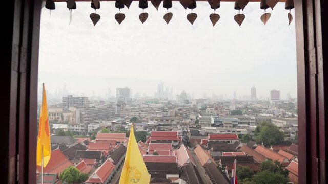4k Walking towards the window. Bangkok view through a window from Wat Saket Temple in Thailand. Phu khao thong, golden mount. Decorative Sacral bells in Ratcha Wora Maha Wihan. Beautiful Day in BKK