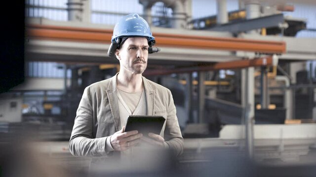 close up of man using smart augmented reality goggle device in industrial plant company