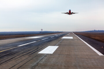 Plane is landing . Airplane over the runway strip