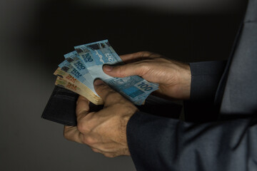 Imagem mostrando dinheiro brasileiro em situa&ccedil;&atilde;o que pode ser de neg&oacute;cios, compra, pagamentos ou at&eacute; mesmo corrup&ccedil;&atilde;o e subornos.