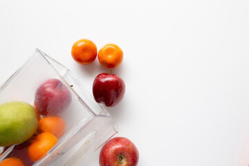apples, pear, orange, banana pouring out of a blender jar