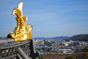 Gold Japanese fish statue on rooftop of Okayama castle in Okayama city, Japan. Believed that it can prevent fire accident.