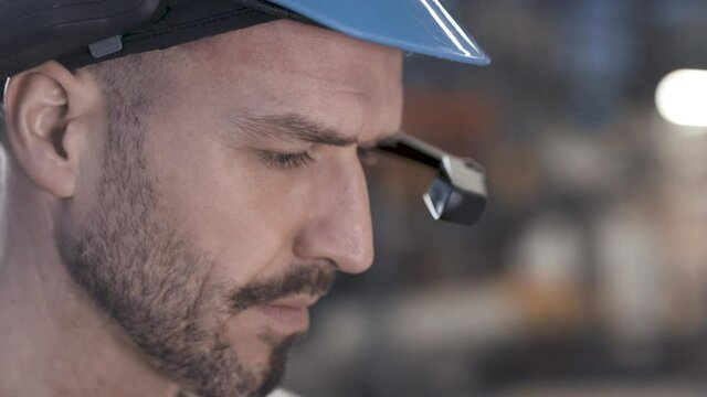Worker using smart augmented reality goggle device in industrial plant company