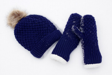 dark blue knit mittens and hat in white snow