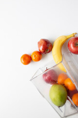 apples, pear, orange, banana pouring out of a blender jar