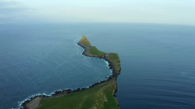 Aerial drone footage of Worms Head in Rhossli bay in Swansea in South Wales, dramatic coastline with tall cliffs
