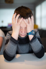 worried boy holding his face
