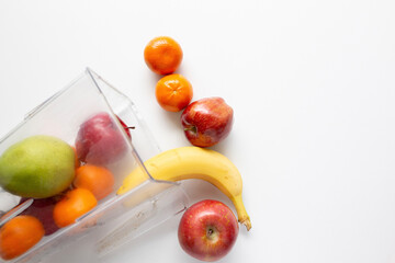 apples, pear, orange, banana pouring out of a blender jar