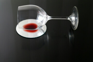 tumbled glass with the remnants of red wine on a black background