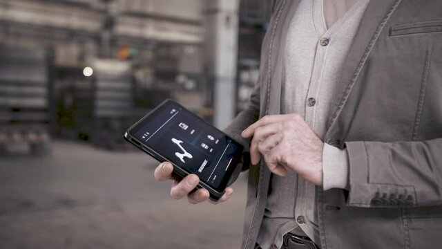 Mann bedient Tablet in smarter Produktionsanlage