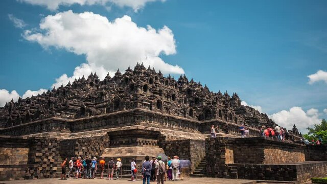 Daytime time lapse view of tourists visiting the ancient ruins of Borobudur, a 9th-century Mahayana Buddhist temple in Magelang Regency near Yogyakarta in Central Java, Indonesia. 