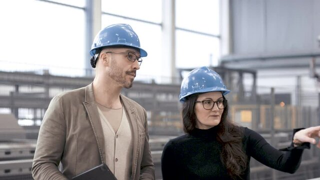 Man and woman walking through industrial plant