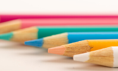 Colored pencils row on white background