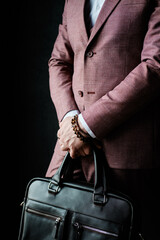 Standing Businessman in Suit with Leather Bag. Elegance Slim Character Man Crossed Hands Holding Laptop Brief Case Isolated on Black Background. Classy Business Style Pose Studio Photo