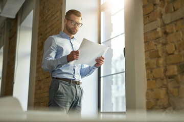 Taking careful look at the working documents by the window