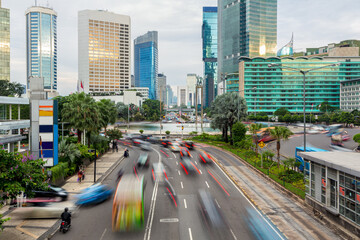 Traffic captured with blured motion drive around the Plaza Indonesia roundabout in Jakarta business...