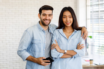 Caucasian businessmen and Asian businesswomen Smiling in plain clothes before going to work in the office. Concept Simple smiling happy diversity.