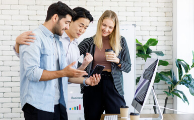 Selective focus on Caucasian businesswomen Look at the smartphone Of colleague diversity, Asian nationality, happy atmosphere, smiling at the office. Concept happy smile meeting.