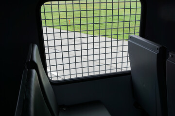 inside paddy wagon, prison car, photo through bars

