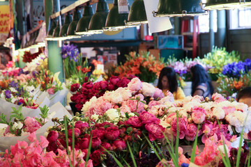 Fototapeta na wymiar Flowers for sale in the high stalls at the Pike Place Market. This farmer market is a famous sight in downtown of Seattle.