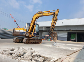 The backhoe drill the floor to make the base of the roof structure.