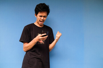 Beautiful young Asian man excited when he saw the notification on the smartphone