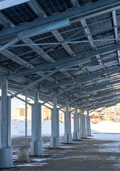 A modern solar carport for public vehicle parking is outfitted with solar panels producing renewable energy.