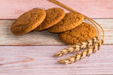 Oatmeal cookies with wheat on a wooden table. Rustic summer style. Cereals, rye and wheat.