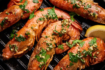 Obraz na płótnie Canvas Grilled large shrimps with lemon and spices on the grill pan