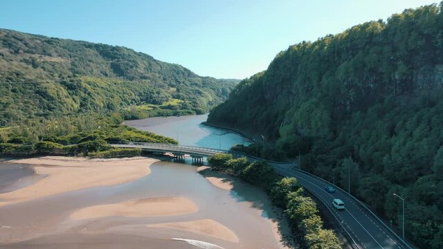 Aerial shot of amazing Maconde beach on beautiful sunny day as traffic drives by.