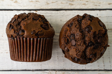 Chocolate cupcake with chocolate drops. Rustic wood background