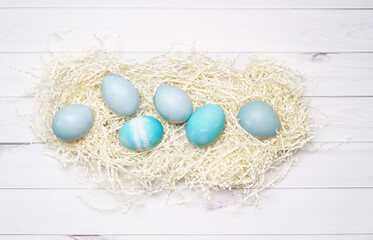 Blue eggs for Easter decor on wood background.