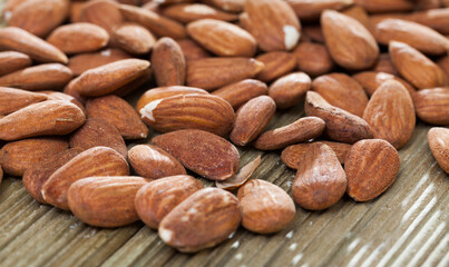 Obraz premium Close up of roasted almonds on wooden background