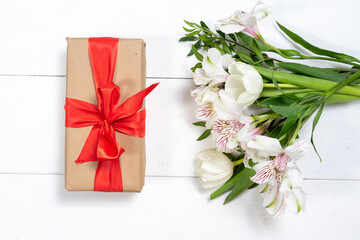 composition of a gift box, and a bouquet of flowers. holiday and congratulations concept