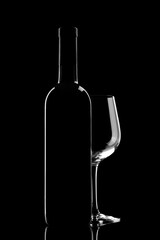 red wine bottle and wine glass isolated on black background