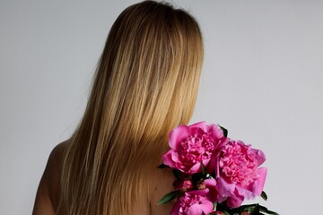 girl with long blond hair and beautiful bouquet flowers pink peonies