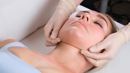 Fototapeta na wymiar Chin massage of woman young woman during face massage at beauty salon