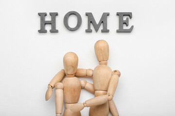 Wooden mannequins with word HOME on white background