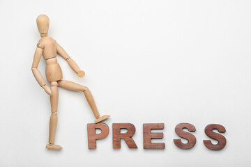 Wooden mannequin with word PRESS on white background