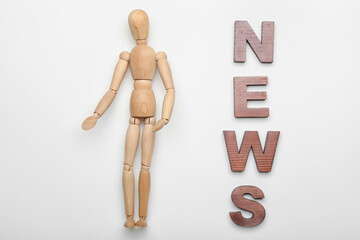 Wooden mannequin with word NEWS on white background
