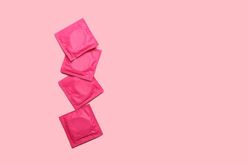 Wrapped condoms on color background