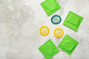 Wrapped and open condoms on light background