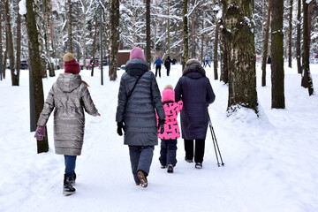 People walk in the snowy city park